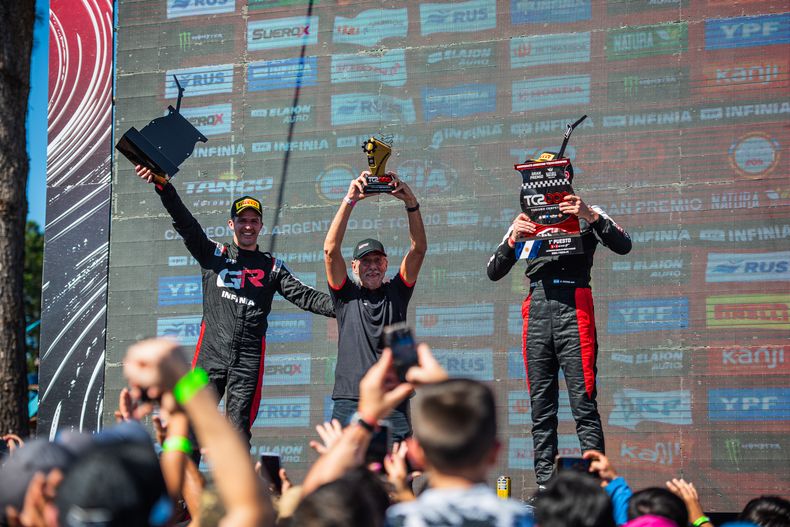 PODIO TOYOTA. Rossi y Stang custodian al jefe del equipo, Darío Ramonda.