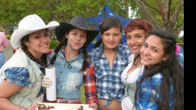 Las chicas de uno de los puestos estudiantiles, poniéndole sonrisas a la tarde..