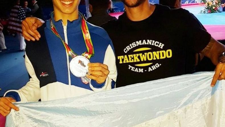 Hoyos muestra la medalla de plata junto a su entrenador, Mauro Crismanich..