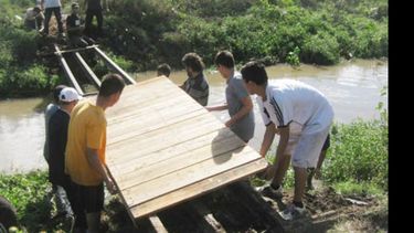 Los vecinos colaborando con el montaje del puente sobre el Pinazo..