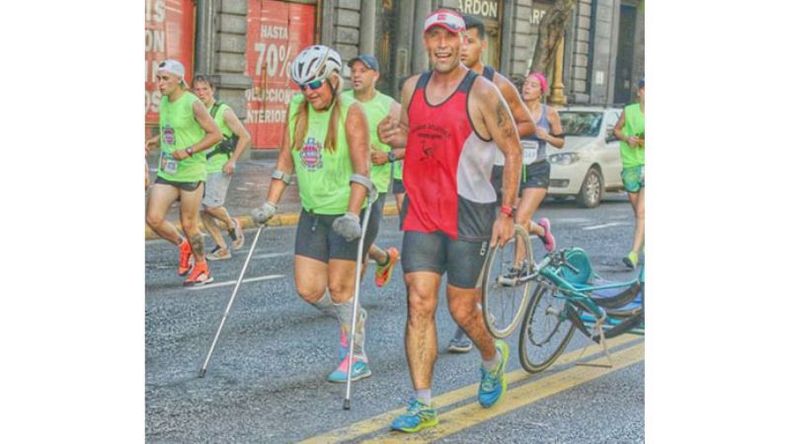 SOLIDARIO. Germán Efler le lleva la silla de ruedas a Norma Ramos, que completó la prueba en muletas..