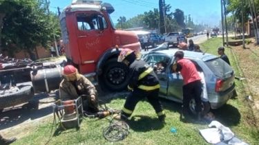 ATRAPADA. Los bomberos intentan rescatar a la mujer del interior del auto.