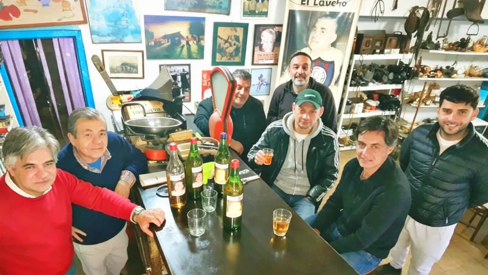 Tito y Cándido Lucas con un grupo de clientes del Bar El Laucha y la infaltable caña con ruda.