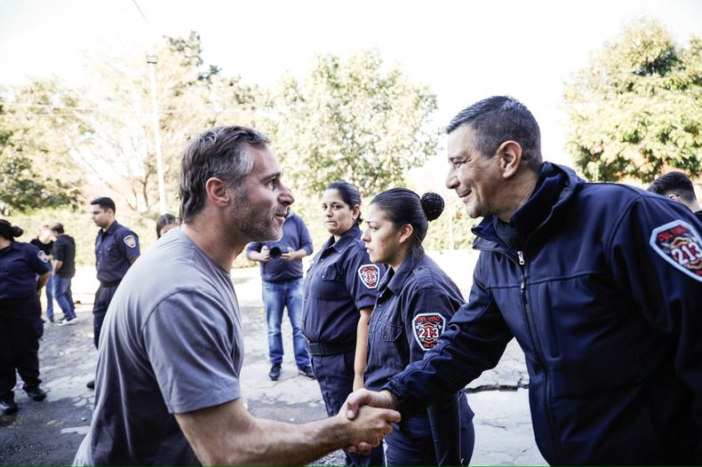 MANO A MANO. Achával saluda a un bombero durante su recorrida por los cuarteles.