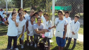 Patio con más verde. Padres, docentes y alumnos de la Escuela Nº 48 durante la plantación de árboles..