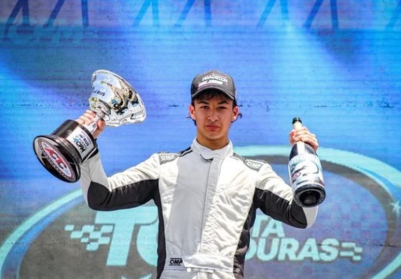 PODIO. Nicolás Jaime posa con el trofeo y el champán.
