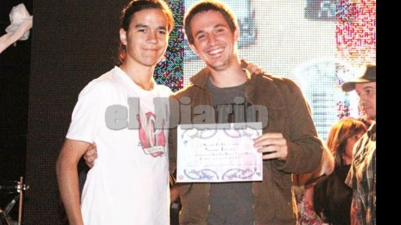 David Martínez le entrega diploma y copia del video a Santiago Ferraro, de la banda Pecado Original..