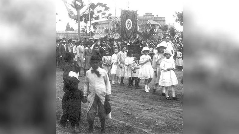 Peregrinación y desfile en el año 1922. Los niños y sacerdotes caminan por las calles eternamente de tierra, sin que se distingan las veredas..