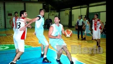 Marcelo Weiter (18 puntos en Atlético) lucha con Nahuel Colaneri, mientras Andrés Dovale busca el aro..