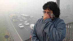 Una mujer busca evitar los efectos de la nube de huno que cubrió la ciudad el 18 de abril. Por la situación, fue necesario hospitalizar a una docena de chicos. .