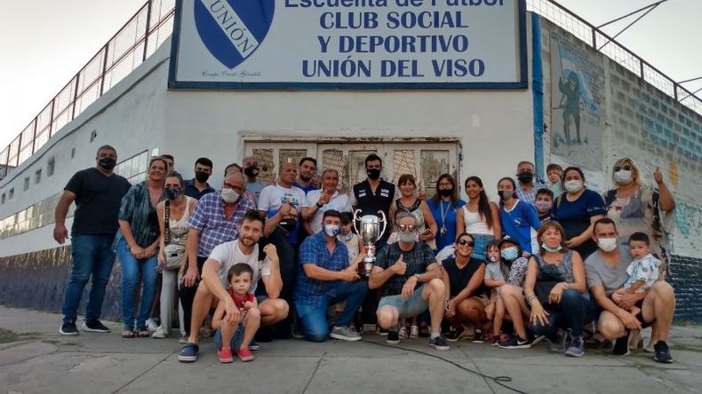 Azar posa en el centro con la copa junto a sus amigos, hinchas y familiares..