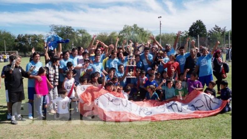 Todo el barrio unido. Los jugadores e hinchas de Agustoni posan con el trofeo de campeón..