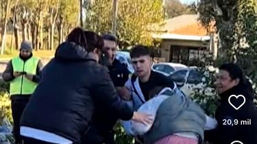 Vecinos intentaron llevarse las botellas caídas del camión y forcejearon con personal de seguridad que custodiaba la carga. Foto: Captura video TN.