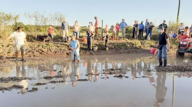 LAGUNA. Los vecinos retirando el agua acumulada en la calle Martel..