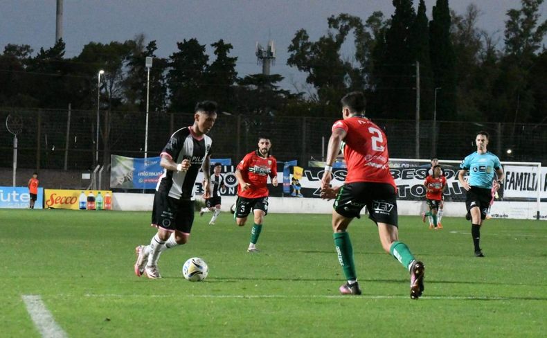 ATAQUE. Federico Martínez intenta superar la defensa de José Cavoret. El delantero destrabó el juego con su movilidad.