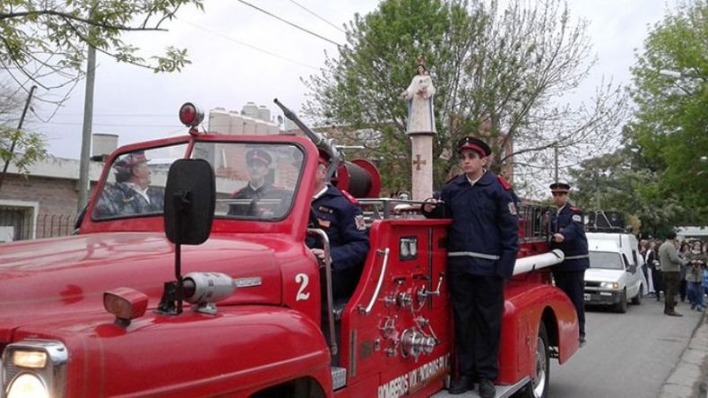 AUTOBOMBA. Los bomberos acompañan la imagen de la Virgen. Atrás, los fieles. .