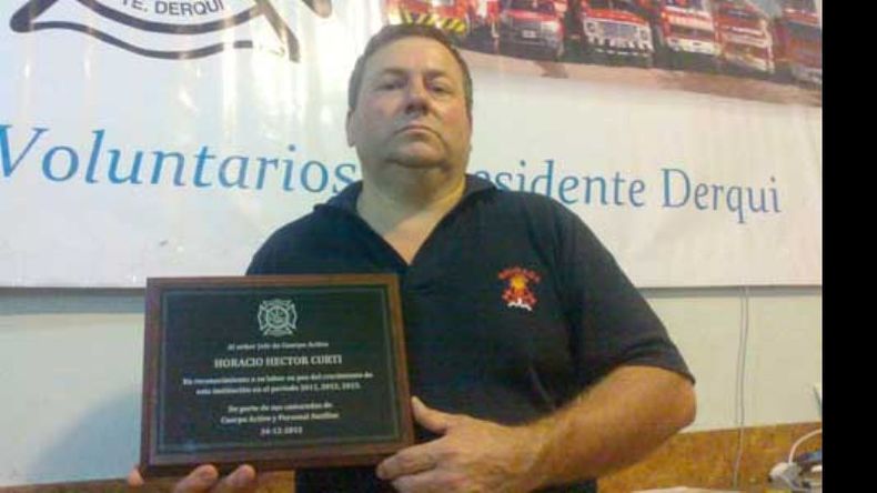 El oficial Horacio Curti muestra su plaqueta..