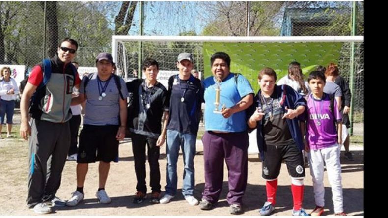 Los chicos del equipo A de Fútbol exhiben las medallas y el trofeo..