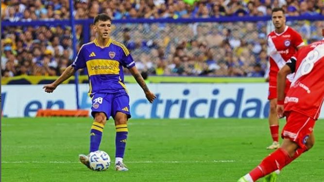 Camilo Rey Domenech con pelota al pie y buscando habilitar a un compañero en una Bombonera repleta. Detrás Tomás Molina (Argentinos).