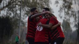 Todos abrazan a Juan Riquelme, autor del gol que valió la punta del campeonato..