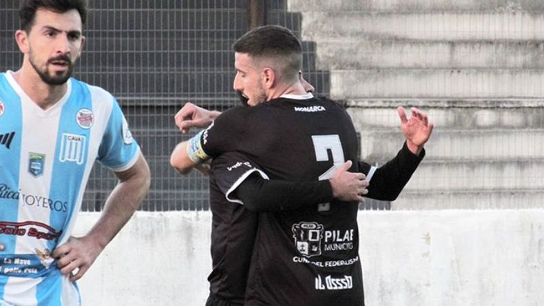 DOS CARAS. Diego Crego abraza a Santiago Tossi, autor de dos goles.Um defensor de Arenas lo sufre. (FOTO: PRENSA REAL PILAR)..