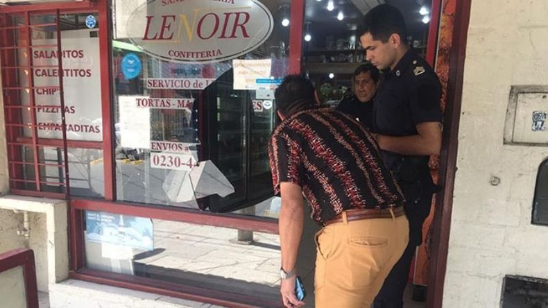 DESTROZOS. El propietario le muestra a la policía los daños sufridos en el local..