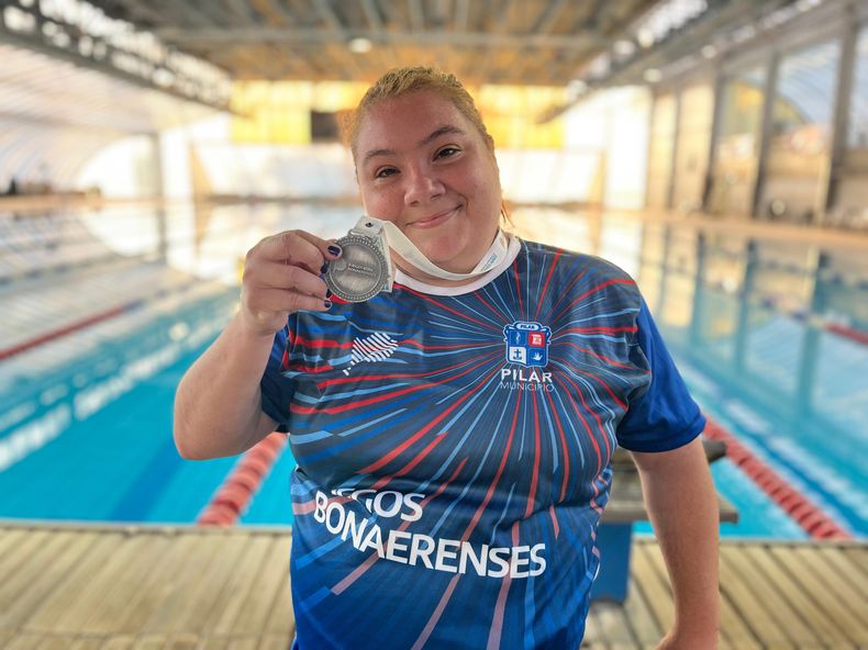 MEDALLA. Patricia Aguirre exhibe la presea de plata con el natatorio de fondo.