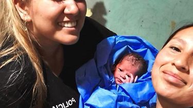 Las mujeres policías junto con la beba recién nacida, tras ayudar a su mamá a dar a luz.&nbsp;
