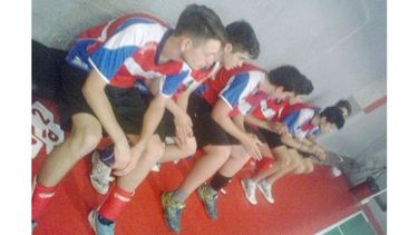 ESPERA. Los chicos de Muni aguardan en el banco el comienzo del partido..