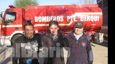 Un grupo de bomberos con su nueva autobomba de fondo..