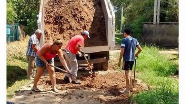A PALEAR. Los vecinos de Río Luján desafiaron el calor y arreglaron si calle..