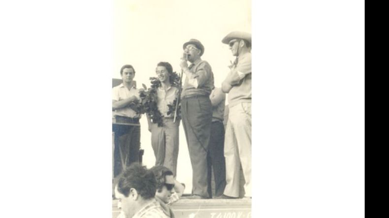 Al micrófono, Silvio Zunino, uno de los promotores del automovilismo local, en una carrera del año 1967 en el circuito de Carabassa. Ese día resultó ganador Fredy Llosa, que celebra detrás del orador. En el podio lo acompañan Aníbal Di Giorio y el Gallego Castro..