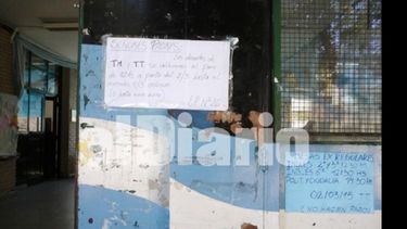 Unos sí, otros no. Carteles en la puerta de la Escuela 26..
