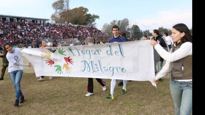 (ALE CANO). TODO POR EL HOGAR. Barovero ingresa a la cancha con los chicos. Atrás, Leo Ponzio..