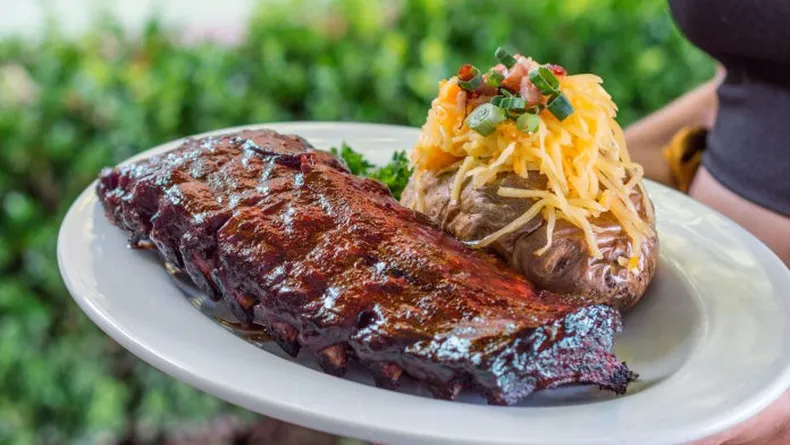 PLATO DESTACADO. Houstons Barbecue Ribs acompañado con papa rellena.