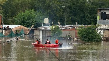 BOMBEROS. Una lancha recorre la zona del río Luján. Su desborde afectó al barrio del mismo nombre.