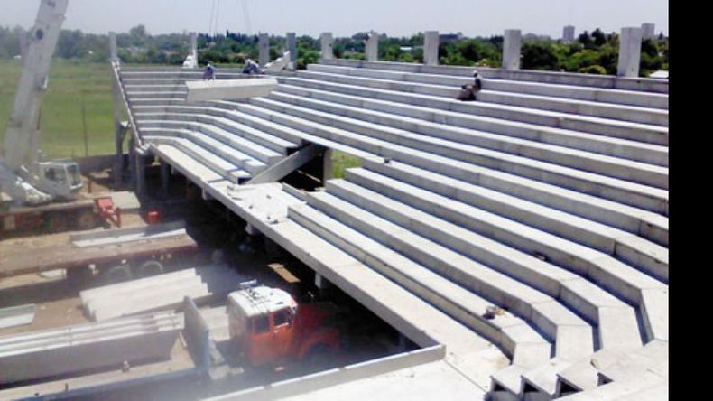 La grúa lleva una de las estructuras de hormigón para colocar en la tribuna..