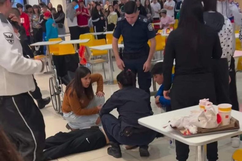 Uno de los heridos tendido en el piso es asistido por personal médico.&nbsp;