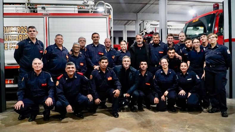 Achával y Laurent junto a un grupo de bomberos voluntarios. Fue durante la visita al Cuartel Central.