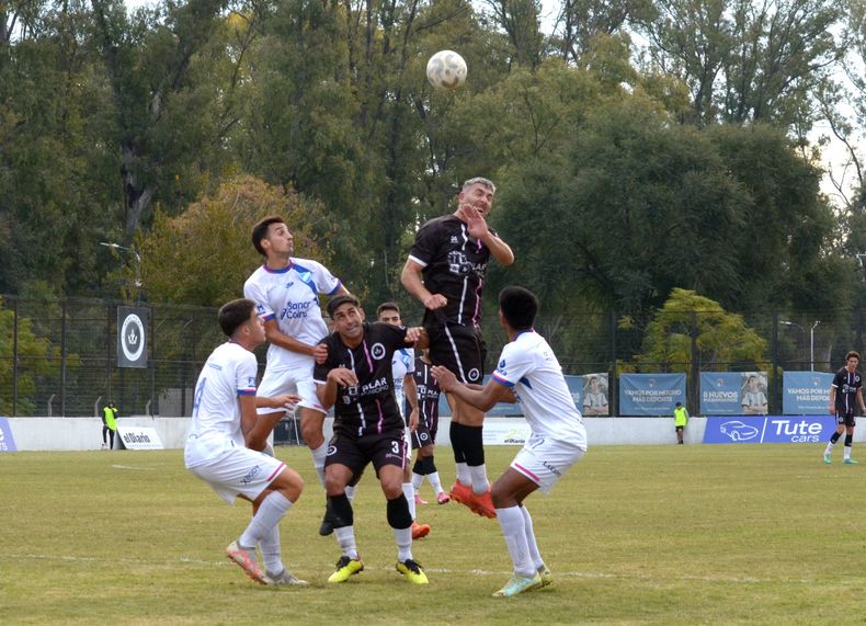 SALTO. Alejandro Noriega gana en las alturas ante Rodrigo Chao y los defensores de Argentino de Rosario.