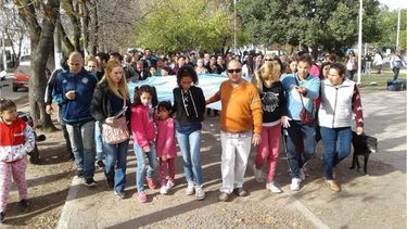 ABRAZO Y BANDERA. Los padres y maestros cantaron el Himno frente a la escuela cerrada..