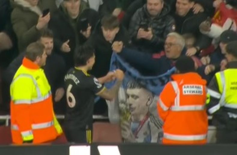 Lisandro Martínez y la bandera hecha por José Pignotti, en la Premier League.