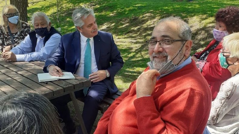 Vázquez en primer plano, detrás Alberto Fernández dialogando con una jubilada..