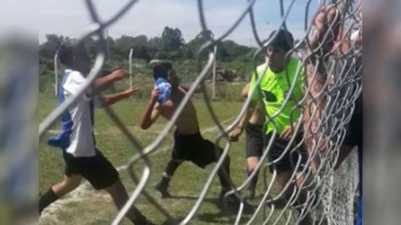 ACORRALADO. El árbitro Moreira contra el tejido intenta escapar de los agresores..