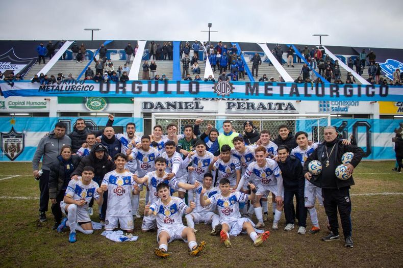 EQUIPO. Todo el plantel de Metalúrgico festeja con su hinchada de fondo el triunfo para ser líder.