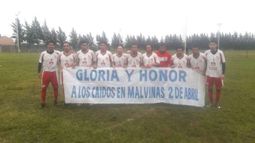 HOMENAJE. Los jugadores de Sportivo, con la bandera recordatoria de Malvinas..