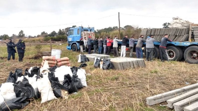 APREHENDIDOS. Los detenidos y los materiales que iban a utilizar para cercar el predio. .