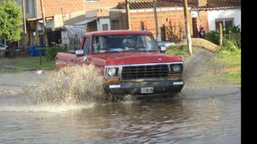Solo agua. Una camioneta atraviesa una calle inundada tras la breve tormenta que sorprendió ayer con fuertes vientos..