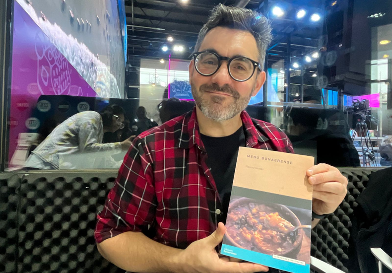 Juan Braceli mostrando el libro Menú bonaerense. (radio.unaj.edu.ar).png