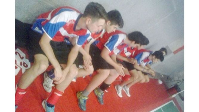 ESPERA. Los chicos de Muni aguardan en el banco el comienzo del partido..